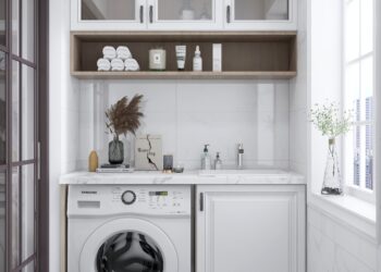 Laundry with white cabinets, white wooden benchtop and frontloader washing machine.